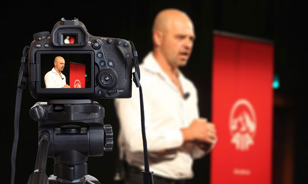 Theo Venter behind the camera presenting a speech.